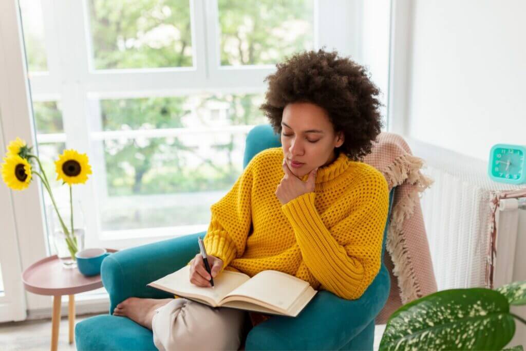 Joven escribiendo en frances en su diario para mejorar su nivel de francés.